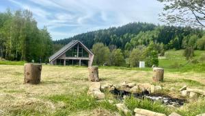 un edificio en medio de un campo con árboles en Slow Life Pod Babią Górą, en Zawoja