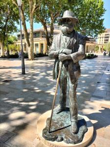 a statue of a man in a hat with a cane at ROTONDE BONAPARTE in Aix-en-Provence +3 photos