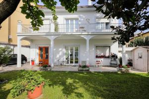 uma casa branca com uma varanda e um quintal em Florence Comfort B&B em Florença