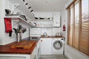 a kitchen with white cabinets and a washer and dryer at Cozy 2BR Flat Central London Sleeps 3 in London