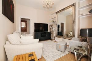 a living room with white furniture and a large mirror at Cozy 2BR Flat Central London Sleeps 3 in London