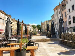 a street with tables and umbrellas in a city at CORDELIERS MAIRIE in Aix-en-Provence