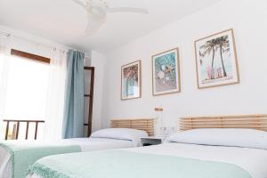 two beds in a room with white walls at Casas Blanca ONLY FAMILIES in Miami Platja