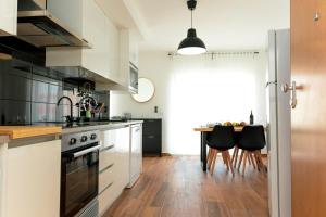 a kitchen with white cabinets and a wooden floor at Gold Apartment Ferrel II in Ferrel