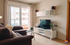 ein Wohnzimmer mit einem Sofa und einem TV in der Unterkunft P Cormoran 3255 in La Manga del Mar Menor
