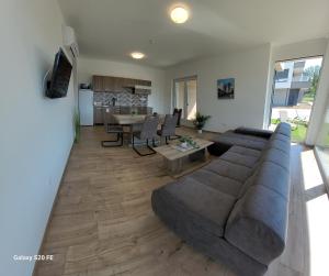 uma sala de estar com um sofá e uma mesa em Zea Apartmanház em Balatonfenyves