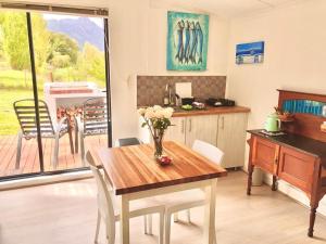 una cucina con un tavolo con un vaso di fiori sopra di Riverlea Farm Self-Catering Unit a George