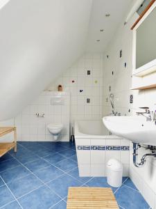 La salle de bains est pourvue d'un lavabo, d'une baignoire et de toilettes. dans l'établissement Sonnensteg 5 - Ein Tag am Meer, à Sellin