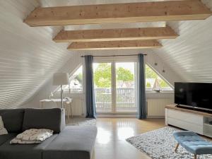 een woonkamer met een bank en een tv bij Sonnensteg 5 - Ein Tag am Meer in Ostseebad Sellin