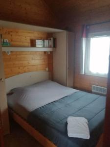Schlafzimmer mit einem großen Bett und einem Fenster in der Unterkunft Le Chalet de Lilie in Bassignac