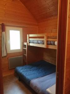 a bedroom with two bunk beds in a cabin at Le Chalet de Lilie in Bassignac