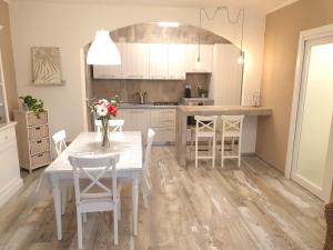 eine Küche mit einem weißen Tisch und weißen Stühlen in der Unterkunft Appartamento Dea in Marina di Campo