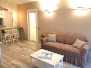 ein Wohnzimmer mit einem Sofa und einem Tisch in der Unterkunft Appartamento Dea in Marina di Campo