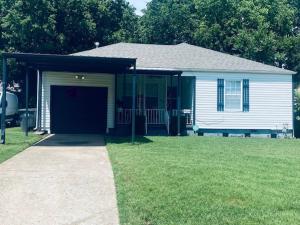 a small white house with a large garage at Xscapecation Oasis in Tulsa