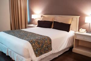 1 dormitorio con 1 cama blanca grande y 2 lámparas en Amérian Buenos Aires Park Hotel en Buenos Aires