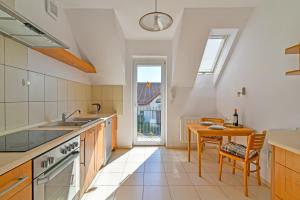 a kitchen with a table and a dining room at Apartament Morski Rewa in Rewa