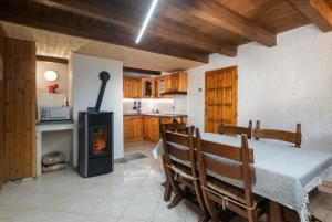 cocina con mesa y estufa de leña en TATRYSTAY Chalet Kristina, en Demänovská Dolina