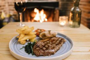 a plate of steak and chips and a glass of wine at The Kings Arms in Coggeshall