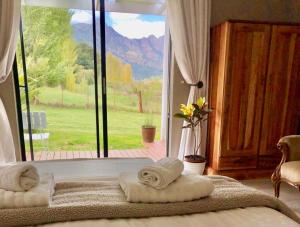 una camera da letto con due asciugamani su un letto con finestra di Riverlea Farm Self-Catering Unit a George