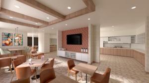 a dining room with tables and chairs and a kitchen at Hyatt Place Sacramento International Airport in Sacramento