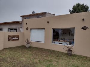 a building with two potted plants in front of it at La Pascuala in Balneario Claromecó +14 photos