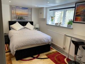 a bedroom with a bed and a desk and two windows at Lux Double Bed Studio by town & beach in Ryde