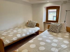 1 dormitorio con 2 camas y ventana en Istrian house Casa del nonno, en Šmarje