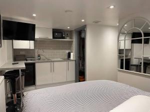 a white kitchen with a bed in a room at Lux Double Bed Studio by town & beach in Ryde
