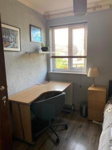 escritorio en un dormitorio con cama y silla de escritorio en Cosy room in cul de sac location’s home en Dagenham