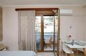 Habitación con cama, mesa y ventana en Niki's apartement en Kavala
