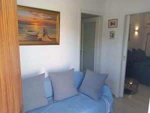 um sofá azul num quarto com uma pintura na parede em Apartment with sea view em Oropós