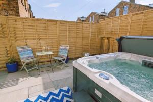 een hot tub op een patio met een tafel en stoelen bij Seaside Escapes - with relaxing hot tub! in Scarborough