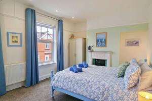 a bedroom with a blue bed and a window at Seaside Escapes - with relaxing hot tub! in Scarborough