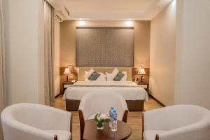 Una habitación de hotel con una cama y dos sillas. en 东都明月酒店Dong Do Minh Nguyet, en Bồ Sơn