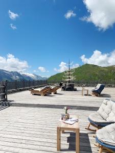 a patio with couches and tables on a wooden deck at Schneekarhütte in Mayrhofen
