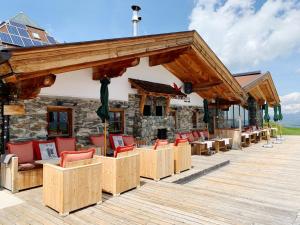 a deck with chairs and tables on a building at Schneekarhütte in Mayrhofen