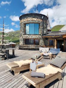 a house with a deck with furniture and a building at Schneekarhütte in Mayrhofen