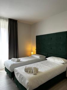 Dos camas en una habitación de hotel con toallas. en PFA Hotel - Isola d'Elba en Cavo