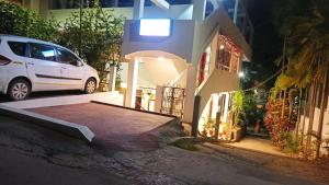 a white car parked in front of a house at night at The Lotus Home in Port Blair