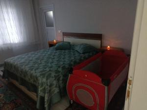 a bedroom with a bed with a green and red comforter at Kadı Home 