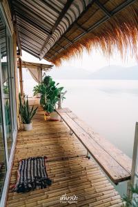 a wooden deck with a bench and plants on a house at Hometown Riverview - โฮมทาวน์ ริเวอร์วิว in Si Sawat