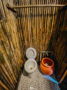 a bamboo bathroom with a toilet and a pot at Hometown Riverview - โฮมทาวน์ ริเวอร์วิว in Si Sawat