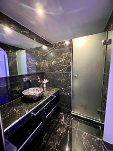 La salle de bains noire est pourvue d'un lavabo et d'une douche. dans l'établissement Anezina Villas, à Perissa