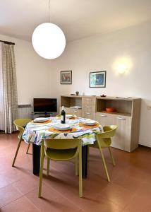 a dining room with a table and yellow chairs at Appartamenti Portiglioni-Cipressi in Puntone di Scarlino