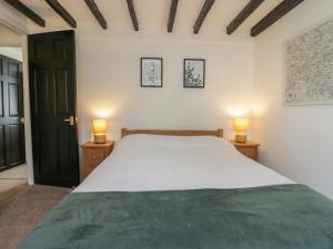 um quarto com uma cama e 2 candeeiros nas mesas em The Cottage em Barrow in Furness