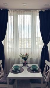 einem Esstisch mit zwei grünen Gerichten und einem Fenster in der Unterkunft Cozy Studio in Cluj-Napoca in Cluj-Napoca