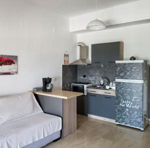 a small kitchen with a couch and a refrigerator at Varka Apartment in Makrygialos