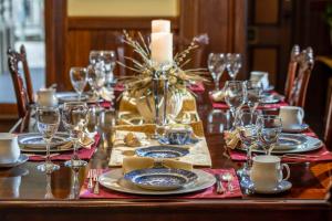 a table set with plates and glasses and a candle at Amelia Island Williams House in Fernandina Beach