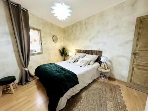 ein Schlafzimmer mit einem großen Bett und einem Kronleuchter in der Unterkunft Maison de village sur les chemins de Compostelle in Saint-Gilles