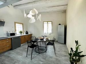 een keuken met een tafel en stoelen in een kamer bij Maison de village sur les chemins de Compostelle in Saint-Gilles
